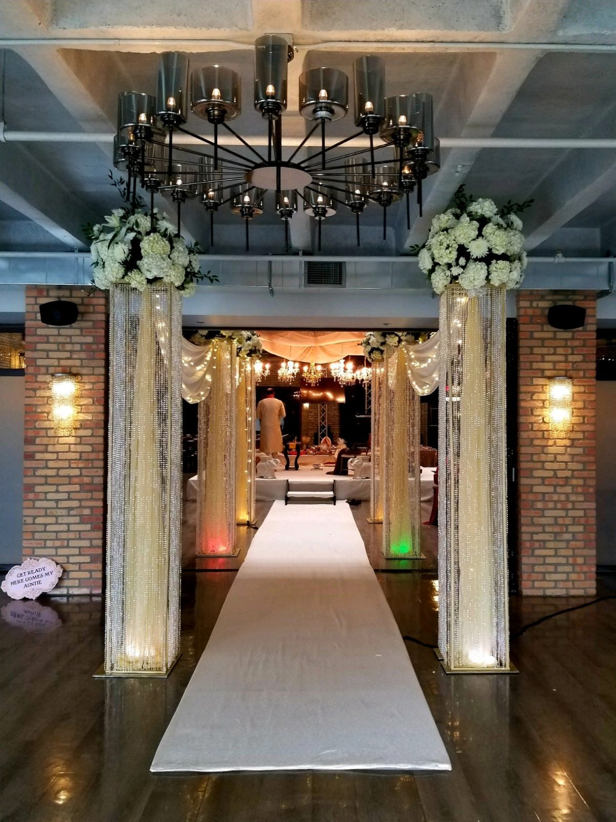 Vibrant sangeet stage with saffron silk drapes, brass urlis and traditional marigolds